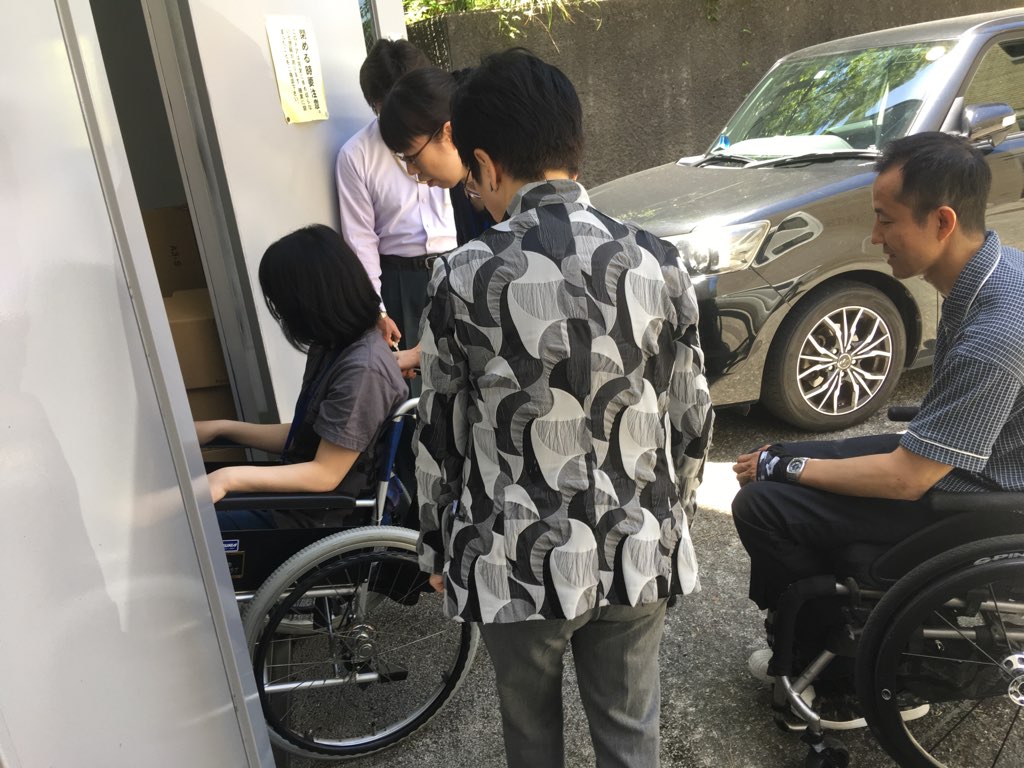 車椅子の人が建物に入っていく様子